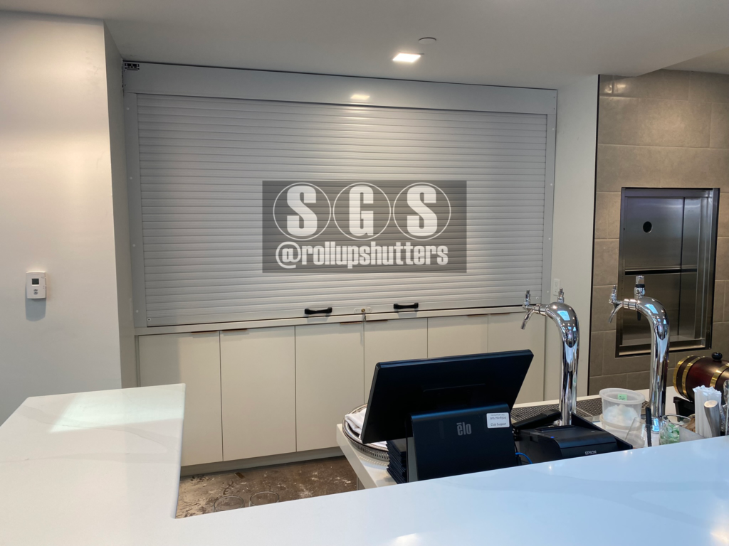 Interior roll shutter installed behind bar counter at The National Club in Toronto